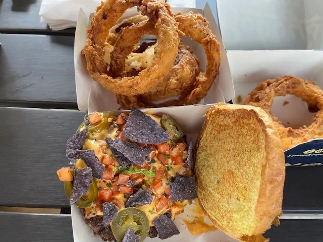 a box with onion rings and an open faced Nacho Burger from Bobby's Burgers In SouthPark